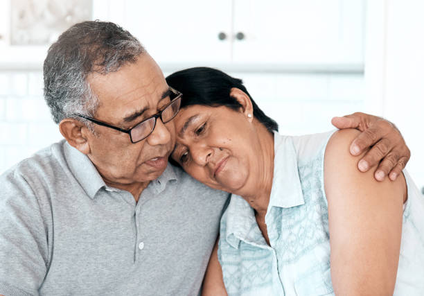 shot of a senior couple looking unhappy at home - common serious couple men imagens e fotografias de stock