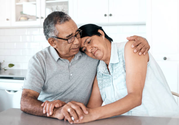 shot of a senior couple looking unhappy at home - common serious couple men imagens e fotografias de stock