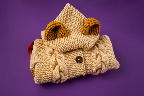 Knitted clothes color background. Handmade children's clothing. Knitted suit close-up stacked. The concept of hobby, individual marketing, entrepreneurship. Autumn is a time of comfort and warmth.
