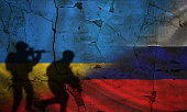 Russland vs Ukraine Flagge auf rissiger Mauer, Konzept des Krieges zwischen Russland und der Ukraine, Silhouette von Soldaten auf Russland vs Ukraine Flagge