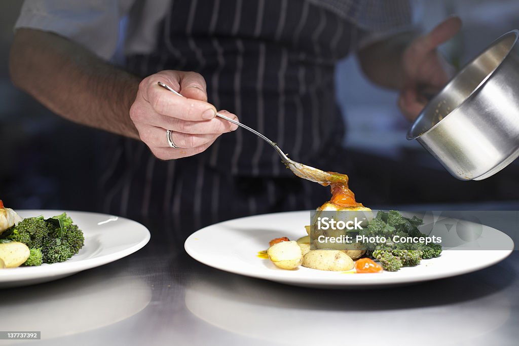 Chef preparing dish in kitchen  Chef Stock Photo