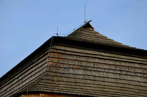Photo of wooden paneling sphere tower shape on viking in carpathian style church. walls and roof truss made of chipped shingle tiles. half of the whole logs similar to a log cabin, baroque house