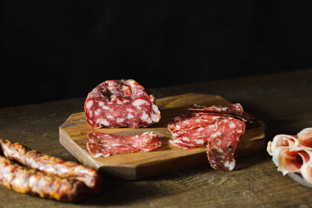 나무 도마에 얇게 썬 살라미 - thin portion salami meat 뉴스 사진 이미지