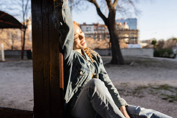 lockige frau, sonnenbäder an ein fenster gelehnt, freizeit entspannt genießen - beautiful boredom sensuality desire stock-fotos und bilder