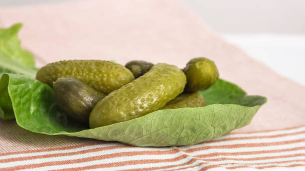 istock Crispy pickled gherkins on a green lettuce leaf on the table 1377408303