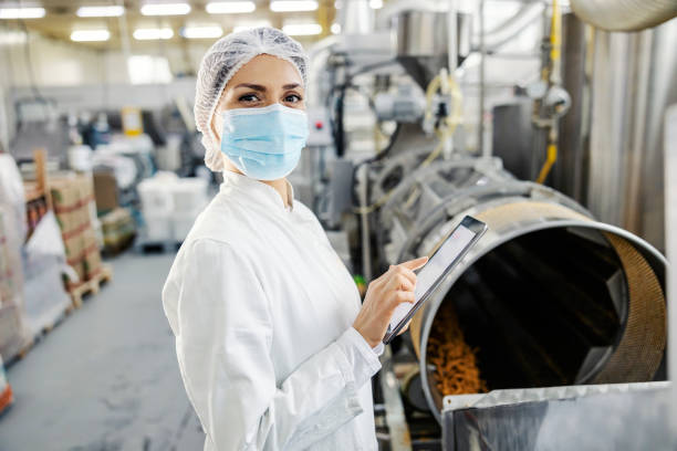istock A food factory supervisor scrolling on tablet and checking on snacks quality while looking at the camera. 1377408888