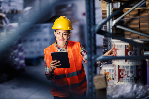 istock A happy female warehouse worker checking in inventory and smiling at tablet. 1377408950