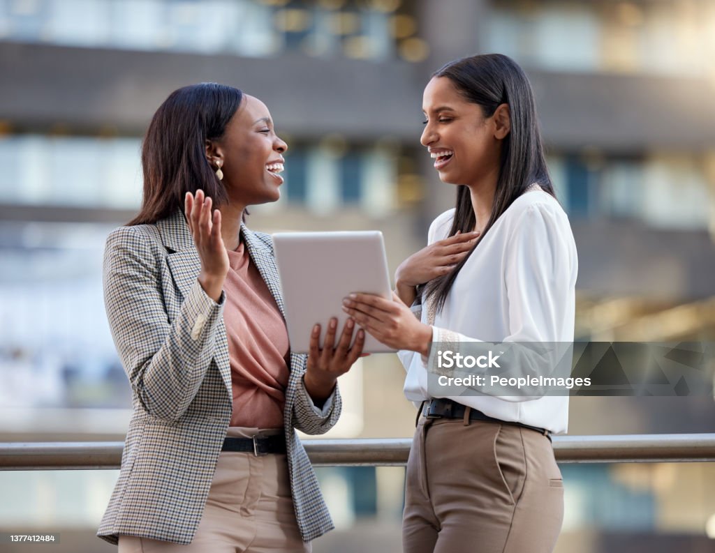 Shot of two young businesswoman using a digital tablet against a city background A cheerful spirit creates a cheerful day Businesswoman Stock Photo