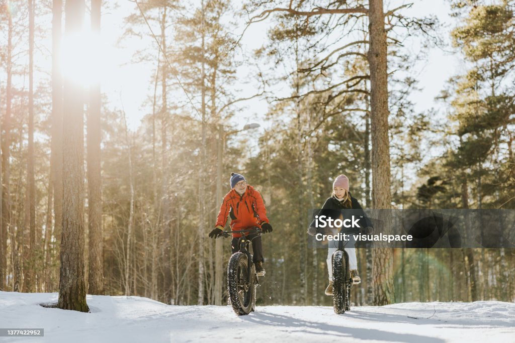 Father and daughter fatbiking in nature Senior father and adult daughter spending the day together, riding with fatbikes in nature. Winter Sport Stock Photo