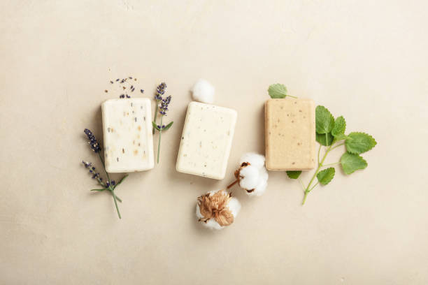 Natural soap bars and ingredients- lavender, cotton, patchouli - on natural stone background, flat lay stock photo