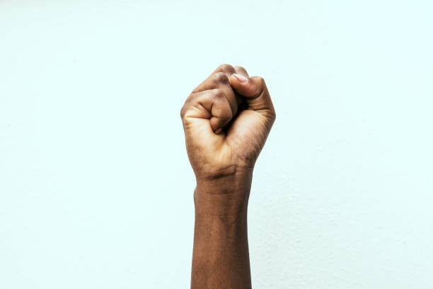 black fist black fist in the air as a sign of power punching the air stock pictures, royalty-free photos & images