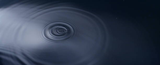 istock Silky smooth surface of water. Gentle waves on dark depth. Single droplet falling down 1377492182