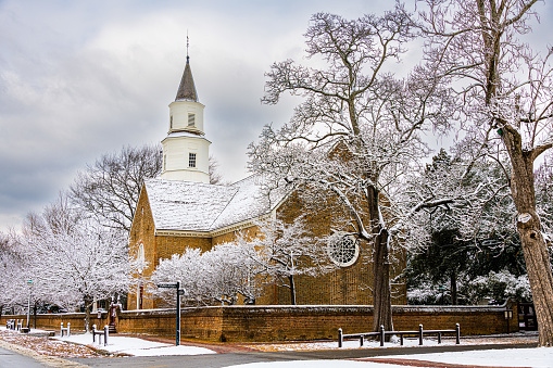 Bruton Parish church stands among trees covered in snow near Colonial Williamsburg, Virginia.