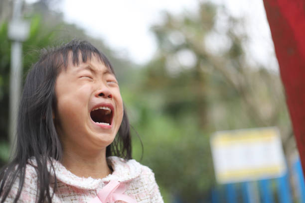 a sad Asian girl crying on the country road.