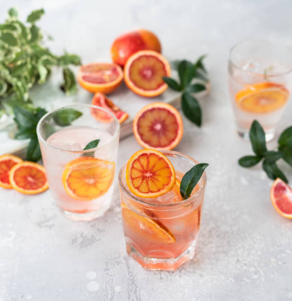 istock Tonic nonalcoholic mocktail with red Sicilian oranges and ice, grey background. Cold refreshing summer mojito lemonade. 1377600071