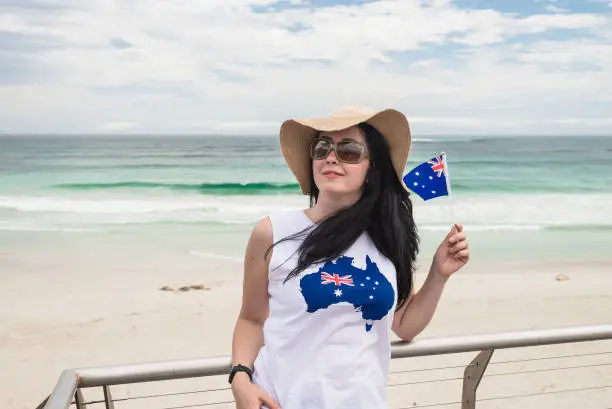 Young woman celebrating Australia Day while holding Australian Flag at Kangaroo Island, South Australia