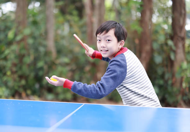Boy playing table tennis in garden stock photo