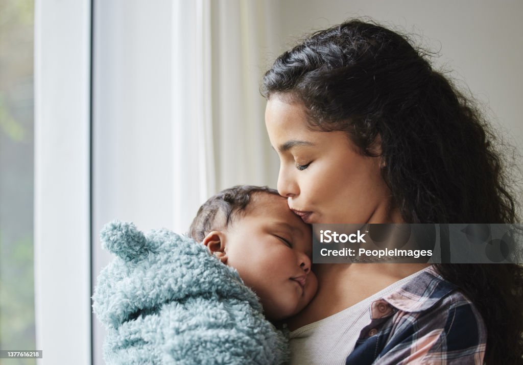 Shot of a young mother giving her baby a kiss at home I'll cherish you for life Mother Stock Photo