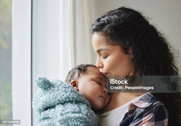 Shot Of A Young Mother Giving Her Baby A Kiss At Home Stock Photo - Download Image Now