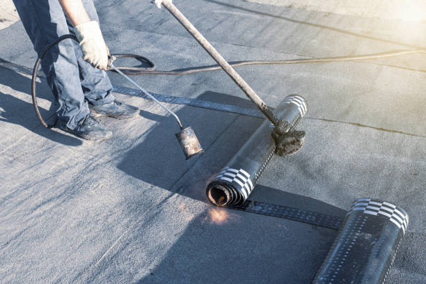 riparazione a molla di un tetto morbido con materiali laminati utilizzando un bruciatore a gas, la parte anteriore e lo sfondo sono sfocati con un effetto bokeh - musica industrial foto e immagini stock