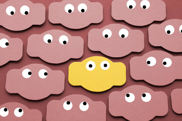 Googly eyes on paper with standing out from the crowd.