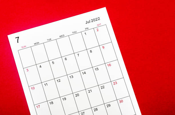 istock July 2022 calendar sheet on red background. 1377657873