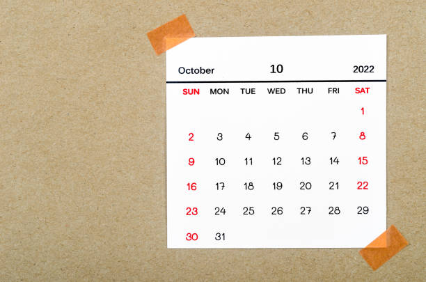 October text displayed on a wooden block against a wooden background with Copy Space. Simple seasonal arrangement.