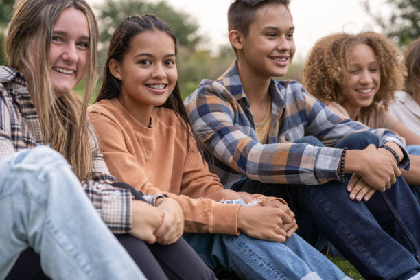 istock Teens Sitting in the Grass on Break 1377677954
