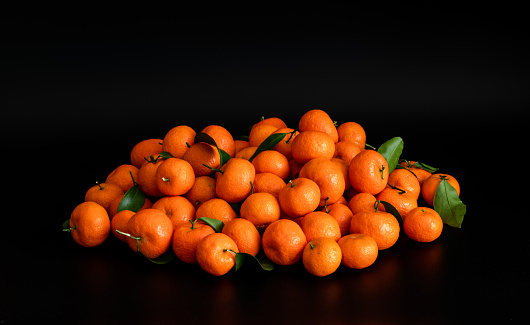 Two ripe tangerines and tangerine slices isolated on a white background. Organic tangerine with green leaf. Mandarin.