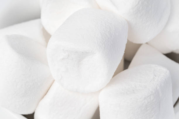 istock Background of marshmallow pieces on white close up 1377687908