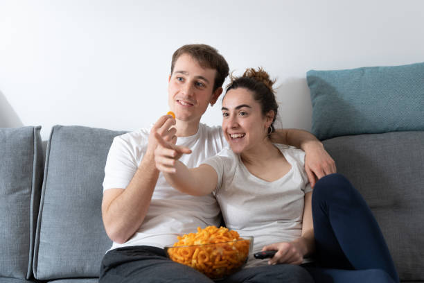 istock Couple eating candy on sofa 1377696260