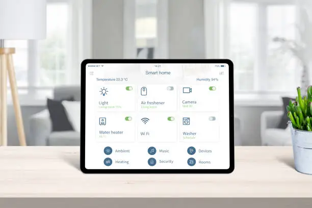 Tablet with smart home app on home desk. Concept of home automatization conrol app with frequently used devices