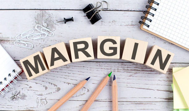 istock MARGIN text on wooden block with office tools on the wooden background 1377710559