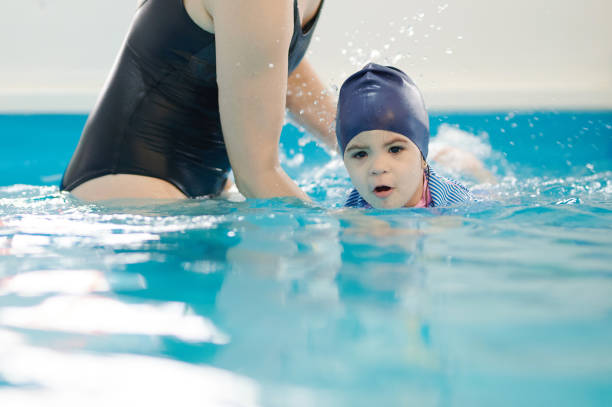 istock Kid learning to swim with teacher 1377713939