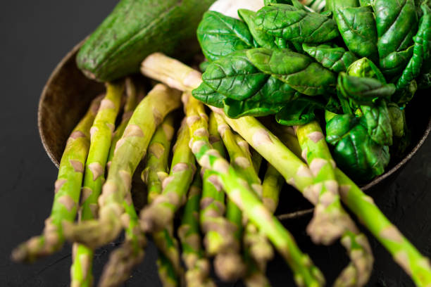 istock Various green vegetables on a dark background. Asparagus, spinach, avocado, garlic. Vegetarian food concept. 1377728986