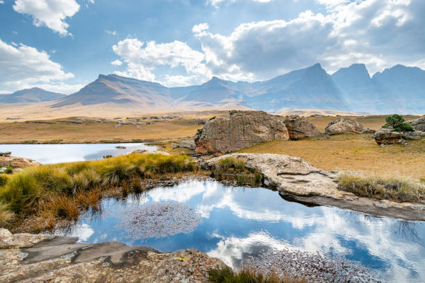 Travel to Lesotho Ponds, grassland and rock formations and hills of Sehlabathebe National Park mirror lake stock pictures, royalty-free photos & images