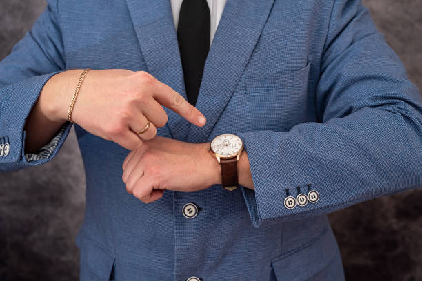 istock A handsome solid man in a chic suit looks at an expensive handsome watch on his wrist. 1377753565