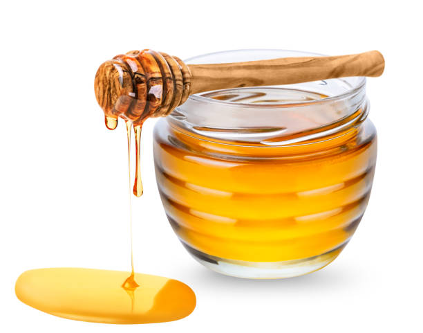 istock Jar with honey and honey dipper isolated on white background. 1377755781