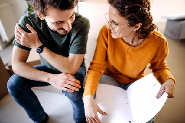 istock Happy couple analyzing plans at their renovating apartment 1377769060