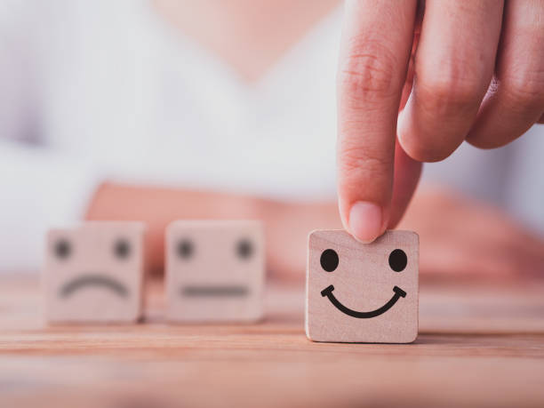 istock Customer service satisfaction survey concept. Customer hand choose happy smiley face, blurred neutral and sad face icon on wood cube to survey feedback, business, rating, review, service satisfaction. 1377790880