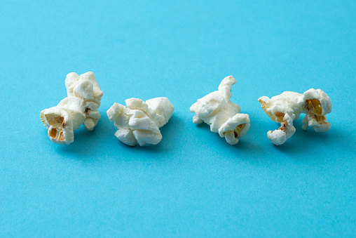 Popcorn in red and white cardboard box. Popcorn border isolated on white. Film. Fast food. Corn