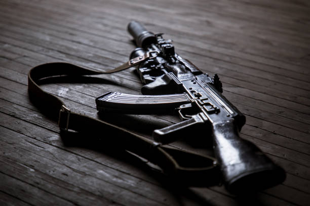 Modern silenced kalashnikov assault rifle on wooden background