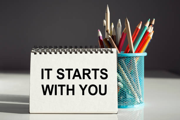 istock IT STARTS WITH YOU - inscription on a notebook with colored pencils. 1377851302