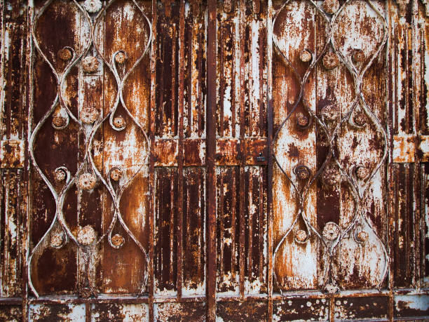 istock Textured rusty metal door of gate, peeling paint. 1377866300