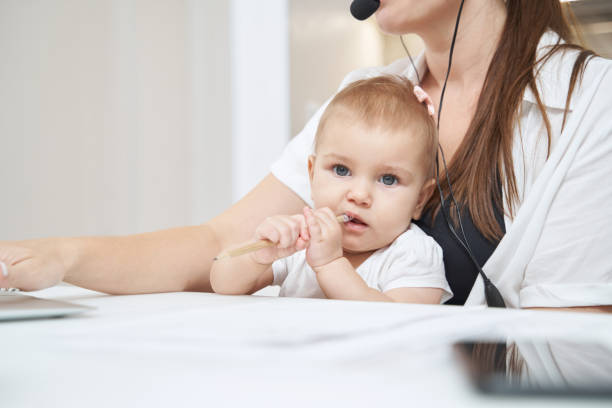 istock Baby biting pencil tip while sitting on mother knees 1377876560