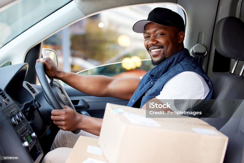 Shot of young man delivering a package while sitting in a vehicle Nothing can slow me down Delivery Person Stock Photo