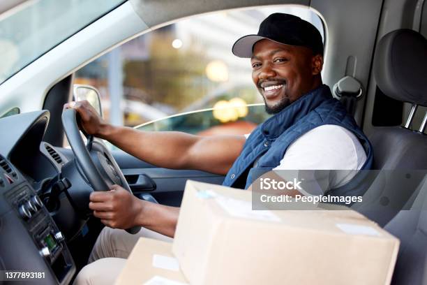 Shot Of Young Man Delivering A Package While Sitting In A Vehicle Stock Photo - Download Image Now