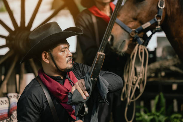 On the ranch, a cowboy prepares for a gunfight On the ranch, a cowboy prepares for a gunfight wild west gunfight stock pictures, royalty-free photos & images