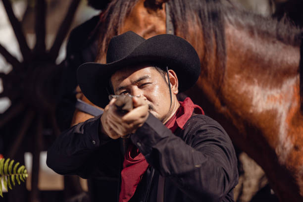 牧場で、カウボーイは銃撃戦の準備をする - cowboy desire west poster ストックフォトと画像