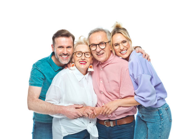 Happy man and woman embracing senior parents Portrait of happy man and woman embracing senior parents against white background. happiness four people cheerful senior adult stock pictures, royalty-free photos & images